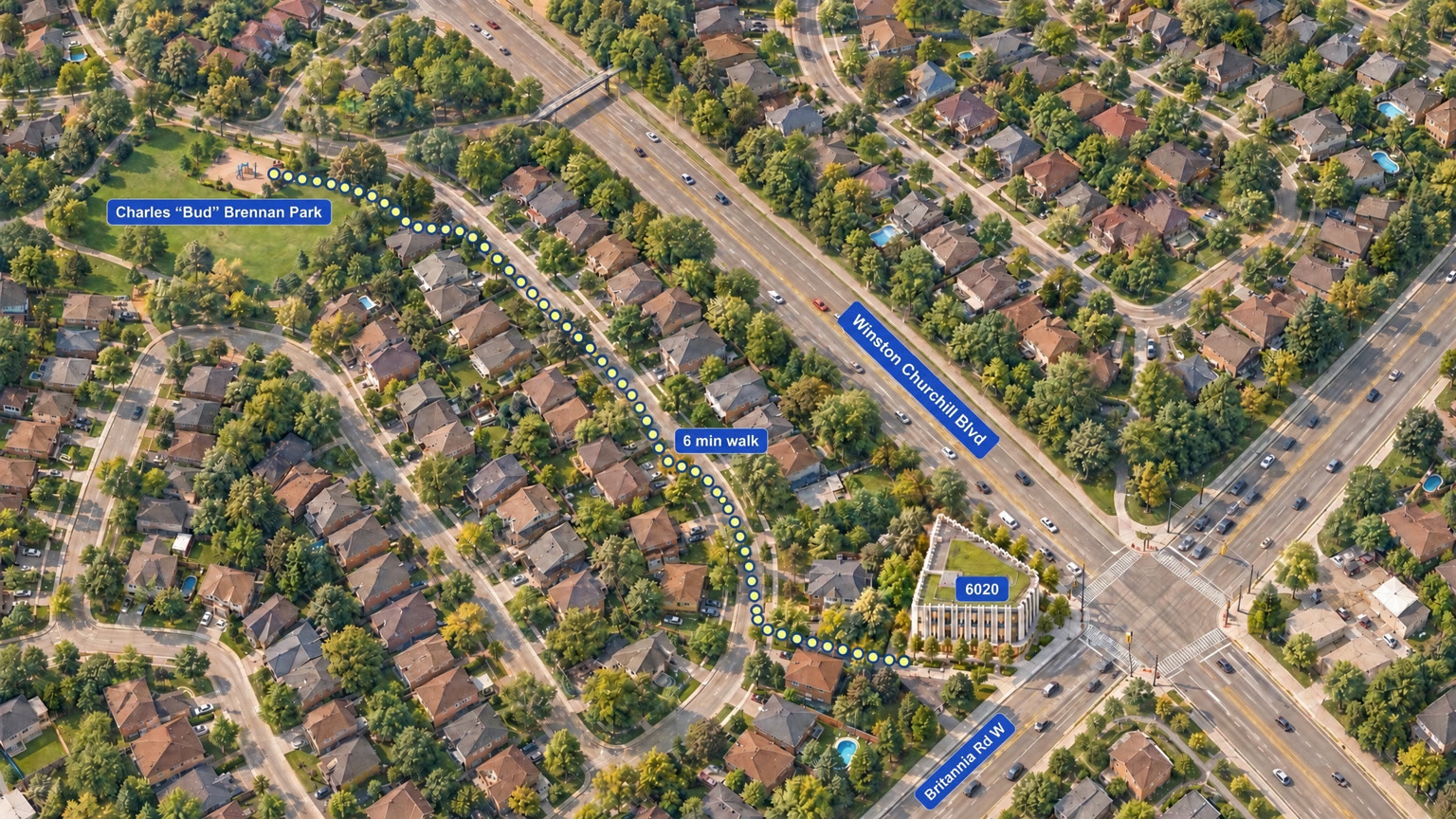 Illustrated aerial view of the corner of Winston Churchill Boulevard and Britannia Road West, with the building on the corner and a dotted walking route through the residential streets behind it to the playground at Charles “Bud” Brennan Park, about a six-minute walk.